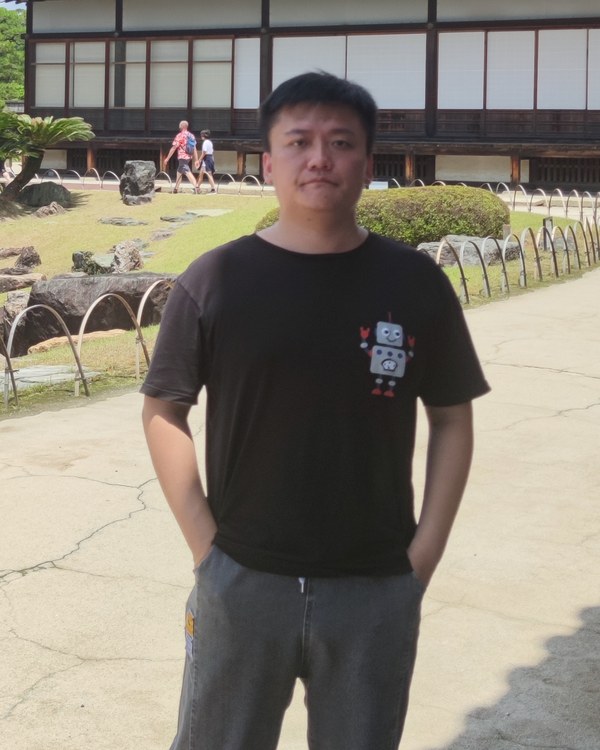 Chi Zhang standing in a garden